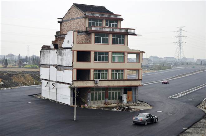 The unique Chinese &lsquo;nail house&rsquo; phenomenon occurs when an owner refuses to sell a house to make way for new development &ndash;&nbsp;like this solitary home adrift on&nbsp;a road in Wenling. (Photo: Reuters)