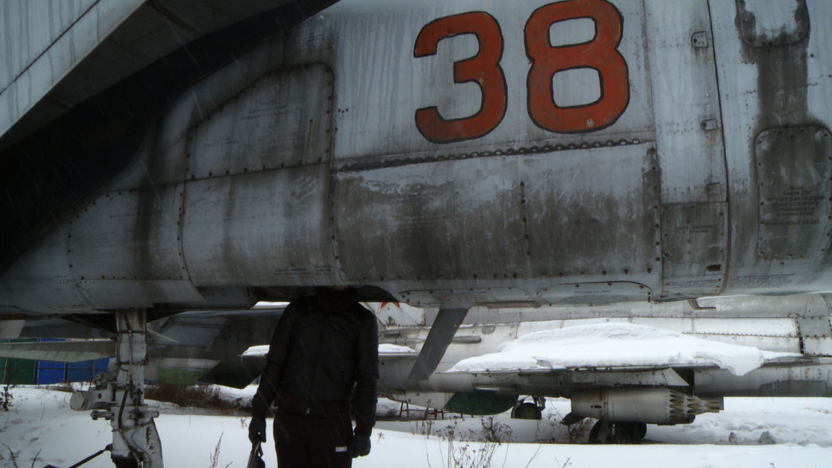 Inspecting the decaying remains of a fleet of Soviet jets. Film still.