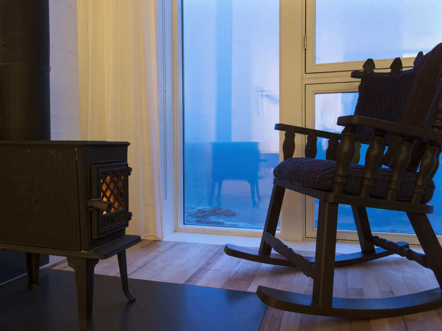 Chair, stove and well-glazed window at dusk. (Photo: Alex Fradkin)