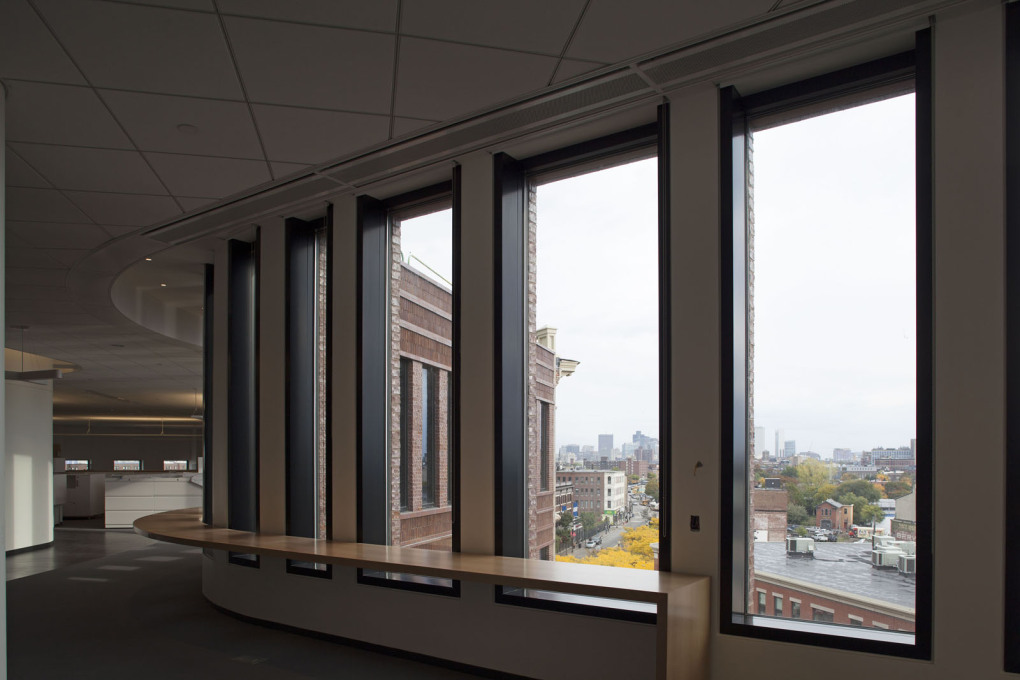 Upstairs, the interior of the building is defined by large open spaces. A table that wraps around the windows provides extra flexible workspace, as well as views of Downtown Boston.