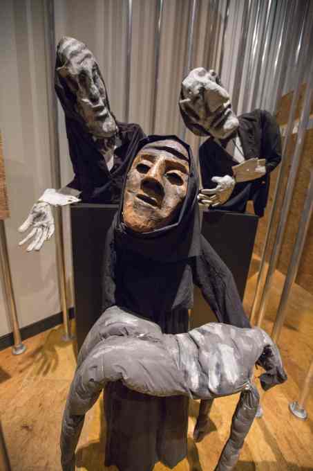 Black-clad puppets, representing Iraqi women, carrying a corpse, follwed by white-gloved businessmen: used frequently by the Bread and Puppet theatre company since 1991, in protest against the Iraq war. (Photo &copy; Victoria and Albert Museum)