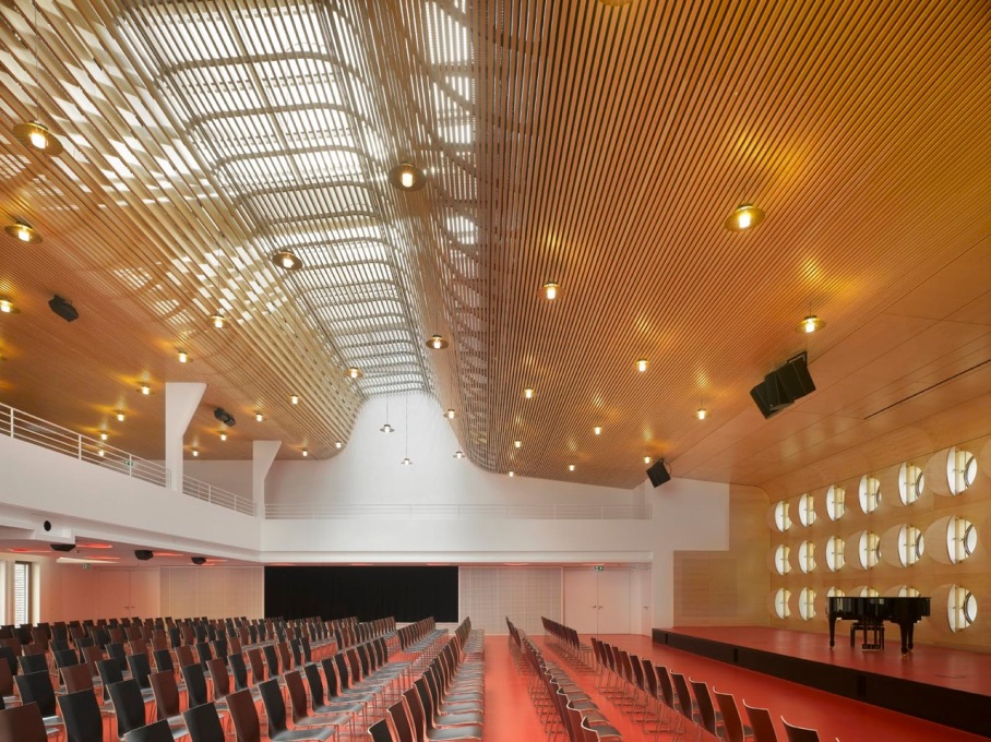 The climax of the design is the main lecture hall, lit by a skylight with a series of curved wooden baffles below gently diffusing the light. Even in this roof detailing, you find a cheerful, open feel to the architecture.