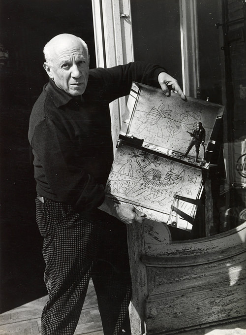 Pablo Picasso at his studio, with photographs of the work in progress on the murals (Photo: C. Nesjar, ca. 1959)
