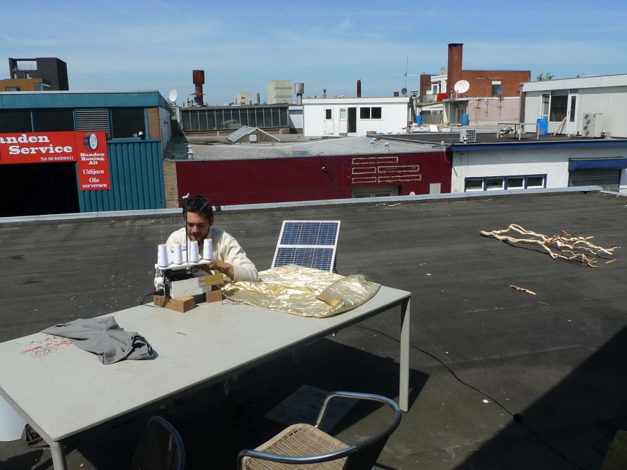 Sewing on solar power and car batteries with a view across the rooftops from the roof terrace.