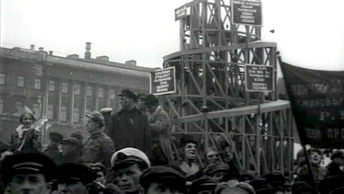 Archival newsreel footage of a Soviet parade, with a wooden model of Vladimir Tatlin&rsquo;s Monument to the Third International (1919-20) carried through the streets. Film still.