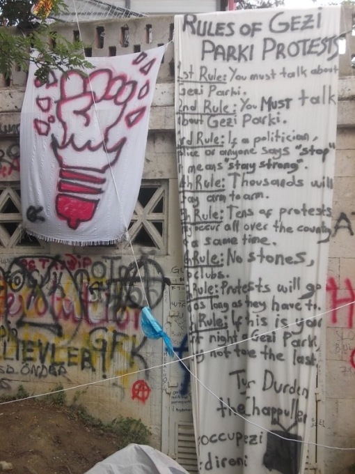 "Thousands will stay arm to arm": A banner hanging inside the park giving out a set of rules and reminders to those who occupied it.&nbsp;(Photo:&nbsp;Merve Bedir)