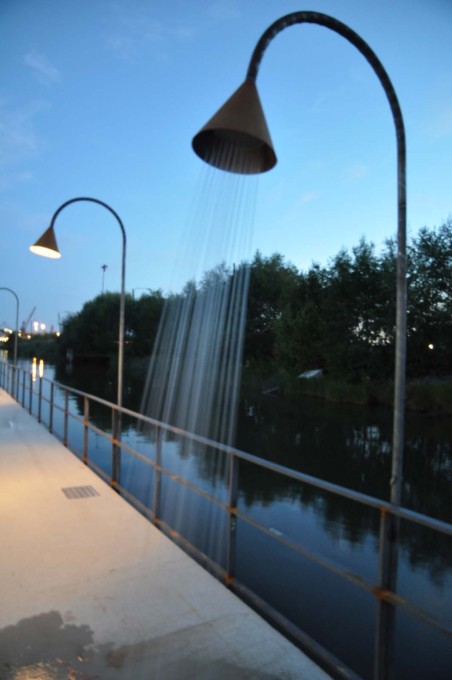 Lamps and showers along the side of the swimming pool are provided by the same metal structures.