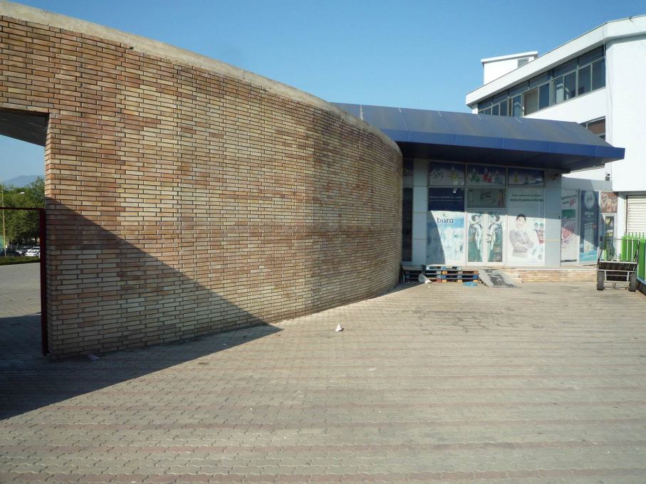 An opening in the brick wall leads to a space where an informal market is often held at the back of the block.
